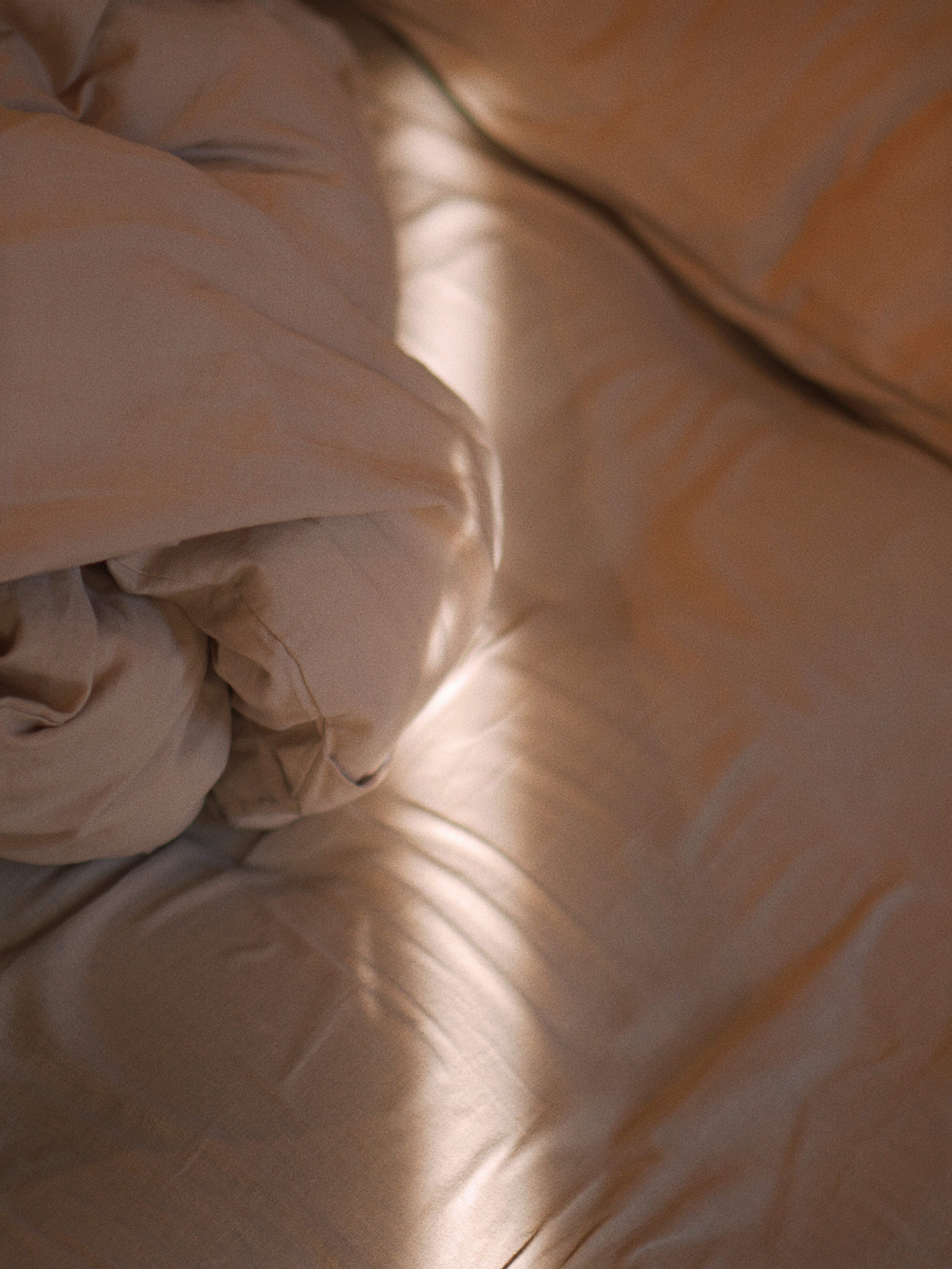 Close-up of beige bedding with a soft focus