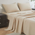 Beige bedspread and pillows on a bed in a bedroom setting.